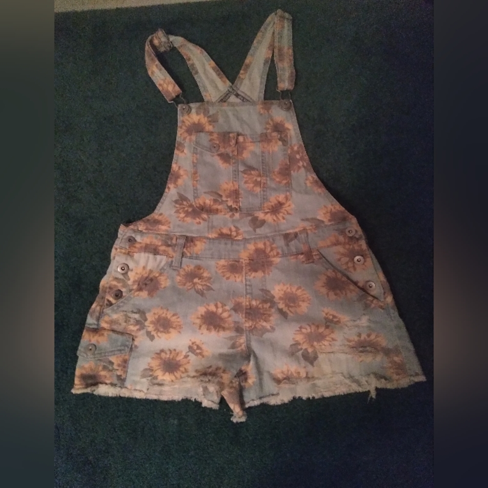 Overalls that are covered in sunflowers
